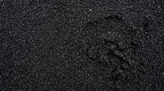 Black volcanic sand texture, dark basalt beach background, natural grainy mineral surface, moody volcanic soil backdrop