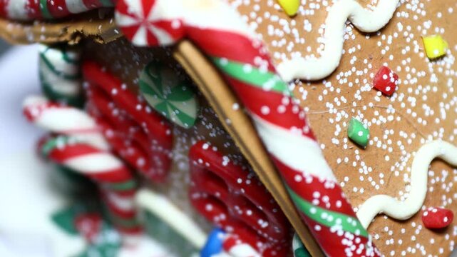 A close-up view of a gingerbread house with intricate details. Rotating in a circle