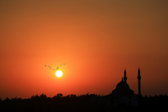 dramatic sunset with birds and 
mosque silhouette