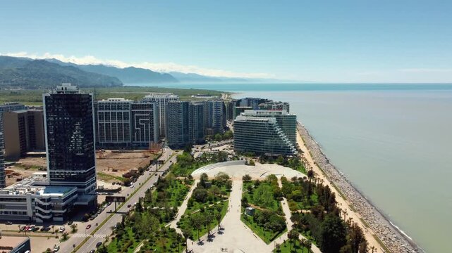 Aerial drone view capturing the expansive lech and maria kaczynski park in batumi, showcasing its modern design, green spaces, and proximity to the beautiful black sea coastline
