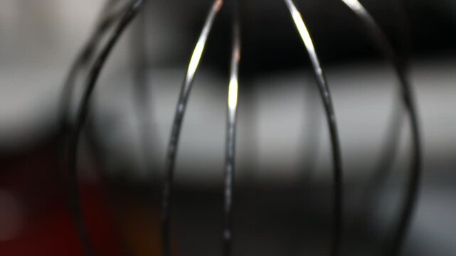 A close-up of a whisk on a table, great for food and kitchen themed images. Rotating in a circle