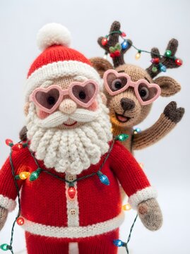 Knitted santa claus and reindeer dolls wearing sunglasses with heart shaped frames and christmas lights
