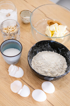 Baking ingredient. Preparing food. Measured sugar salt flour peanut placed in bowl cup for mixing dough on kitchen table background.