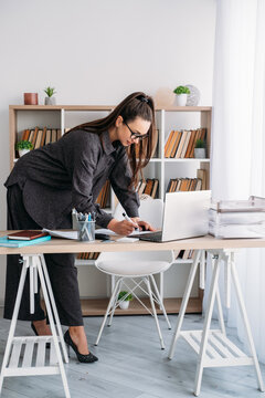 Professional workflow. Office worker. Business woman preparing for occupation at desk with notebook laptop at modern workspace.