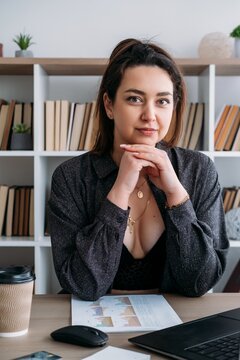 Manager lifestyle. Office atmosphere. Happy positive woman professional at desk with laptop business paper at modern workspace.