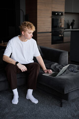 Fototapeta premium Thoughtful caucasian man planning day in modern kitchen lounge
