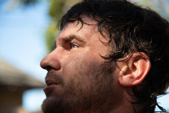 Close-up side view of a man's face outdoors on a summer day