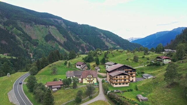 Mountain village with hotel and winding road in a green valley