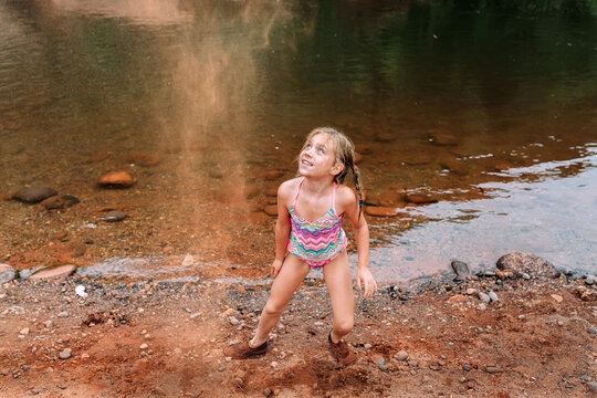 Little Girl Throwing  Sand on Beach in Sedona, Arizona