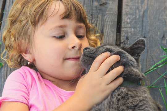 A child loves a cat outdoors. Selective focus.