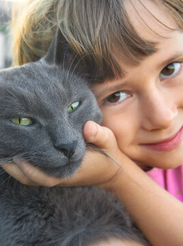 A child loves a cat outdoors. Selective focus.