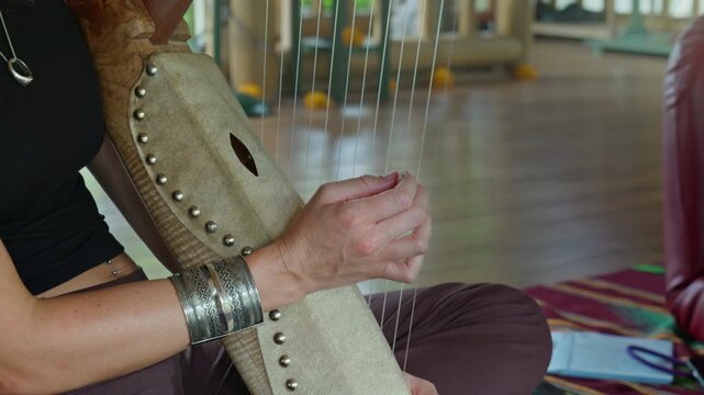 Musician hands playing the harp lyre ethnic musical string instrument