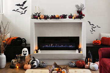Cozy Halloween decor display in a beautiful warm modern living room with burning fireplace and candles