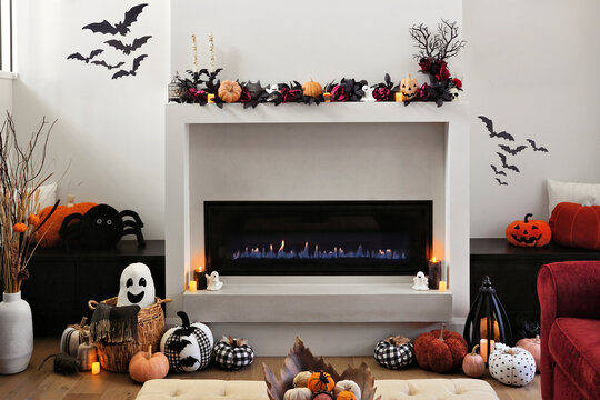 Cozy Halloween decor display in a beautiful warm modern living room with burning fireplace and candles