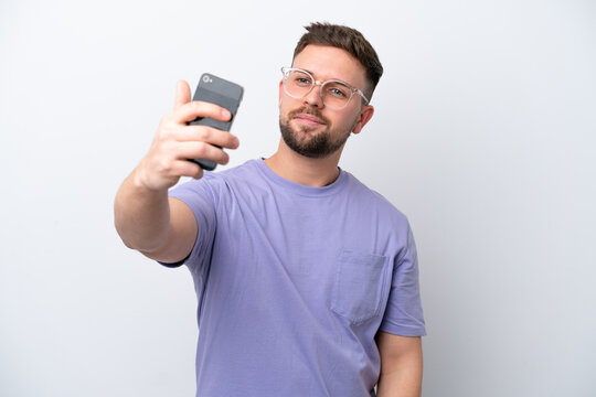Young caucasian man isolated on white background making a selfie