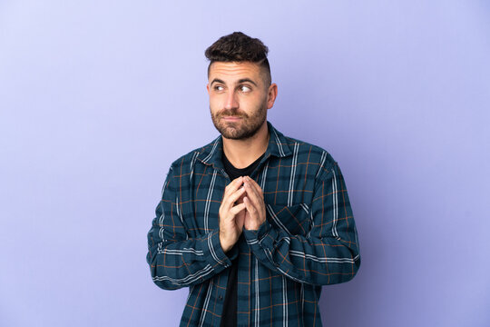 Caucasian man isolated on purple background scheming something