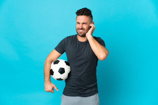 Football player isolated on blue background frustrated and covering ears