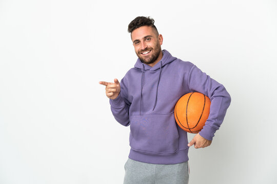 Basketball player man isolated on white background pointing finger to the side