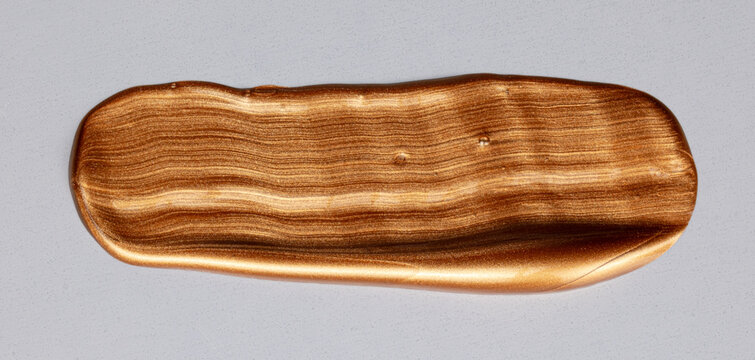 Bronze metallic paint swatch creating abstract smear
