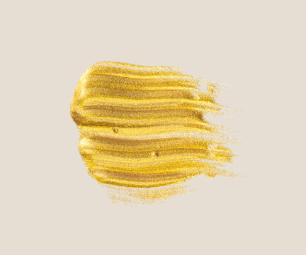 Golden paint stroke with glitter on a light background