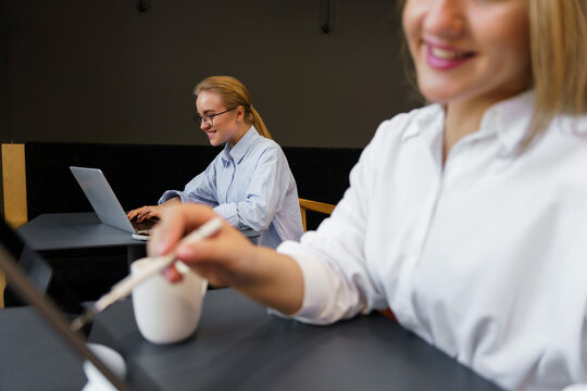 Creative minds collaborating in a cozy cafe setting during a rainy afternoon