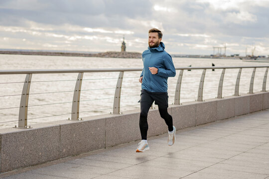 Running along the waterfront path as the sun breaks through the clouds in a vibrant urban landscape