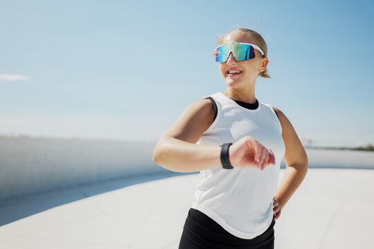 Energetic runner checks time while enjoying a sunny day outdoors
