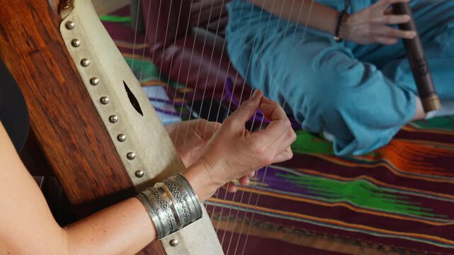 Musician hands playing the harp lyre ethnic musical string instrument