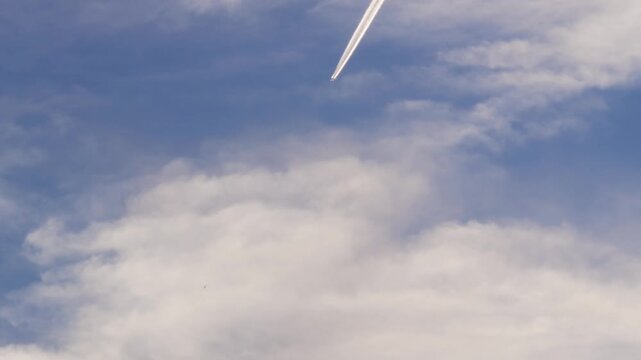 異なる高度を飛ぶ2機の飛行機と1機から白く伸びる飛行機雲