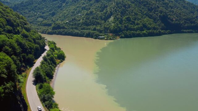 Breathtaking aerial photographs show the natural phenomenon of the confluence of two rivers, where clear green and murky brown water form a clear, unmixed dividing line. Georgia