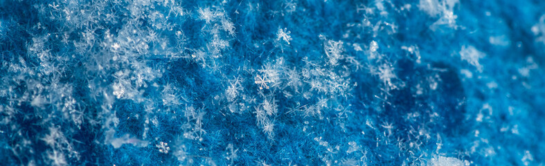 Naklejka premium Individual ice crystals forming unique patterns and creating a beautiful abstract texture on the fuzzy blue surface, showing the intricate details and cold beauty of nature during the winter season