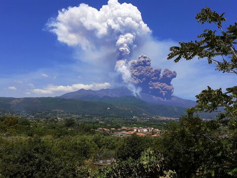 Un'eruzione esplosiva del Vulcano Etna con emissione di gas bianco e sabbia vulcanica nera. Giugno 2025.