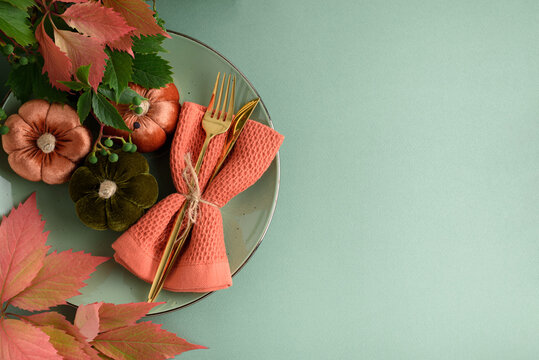 Autumn Table Setting with Velvet Pumpkins Napkin and Golden Cutlery Ready for Thanksgiving Dinner Celebration