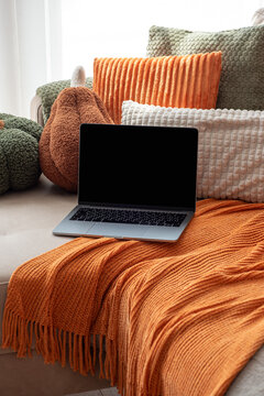 Cozy Autumn Home Office Scene With Laptop And Warm Orange Knitted Blanket And Cushions