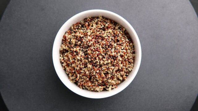 Cooked Tri-Color Quinoa in white bowl. is a superfood high in protein and all essential amino acids and high in fiber.Top view.