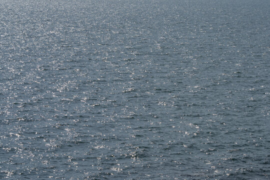 Sunlight sparkling across rippled surface of tropical seawater. Abstract marine background for ocean, nature, travel, summer and environmental design themes. Marine, tourism and tranquil background.