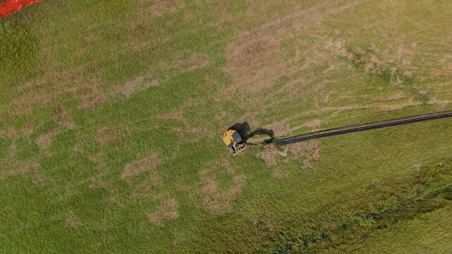 Aerial view of a yellow excavator working along a prepared route for future pipeline installation, illustrating construction activity and underground infrastructure development.