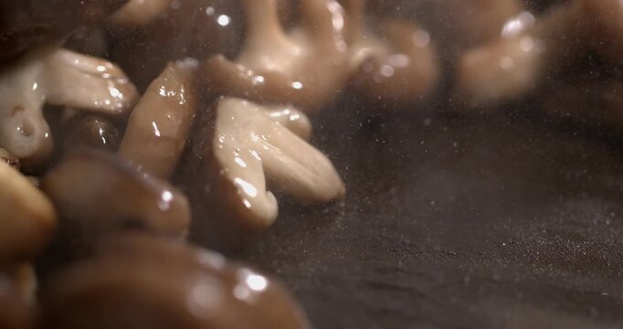 Slow motion cooking with mushrooms and sizzling sounds at a kitchen stove