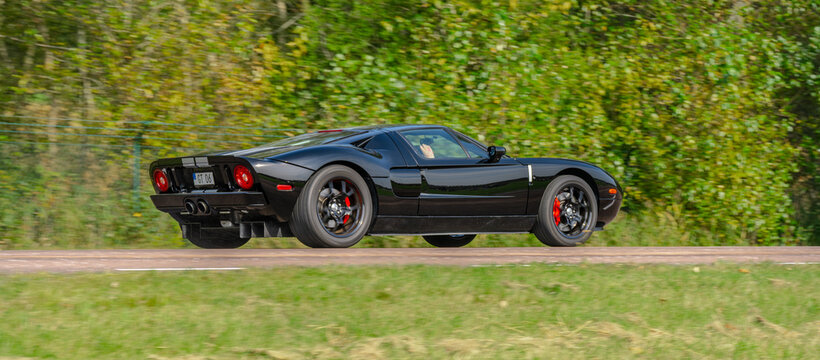 Gothenburg, Sweden - september 07 2024: High performance black Ford GT driving fast past green woodland.