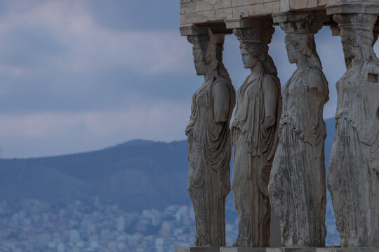 The majestic Caryatids statues of the Porch of the Maidens on the Erechtheion at the Acropolis, Athens, under a moody twilight sky.