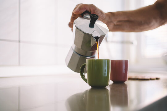 Pouring Fresh Coffee from Moka Pot into Cup 