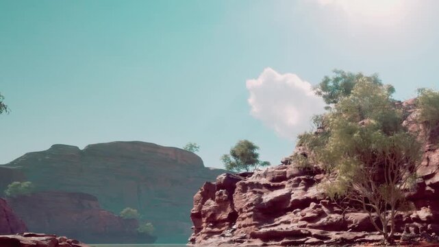 Rocky cliffs next to a body of water with trees growing on the land. The sky is bright with a few clouds visible. This location is likely a remote area in nature.