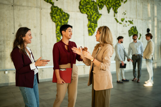 Businesswomen networking in modern office with global map wall