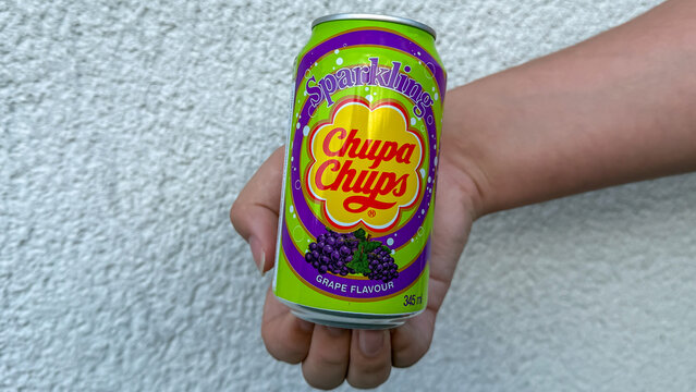 Hand holding chupa chups sparkling grape flavor soda can