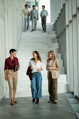 Fototapeta premium Business people walking on office stairs communicating