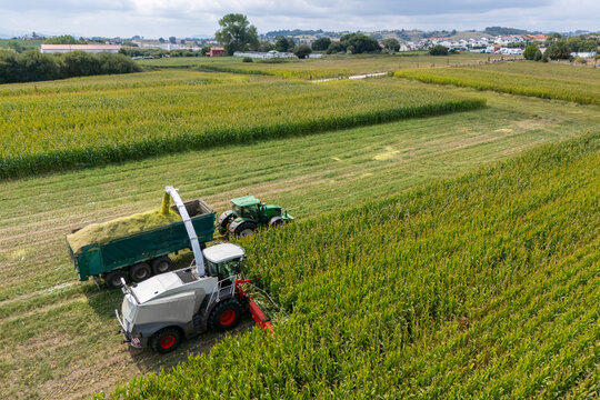 Aerial view of a forage harvester collecting corn and loading it into a tractor trailer