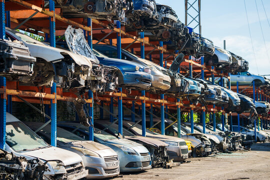 Stacked cars for used auto parts sale at an outdoor junkyard