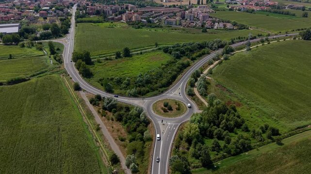 Aerial View of a Modern Roundabout: An aerial perspective showcases a meticulously designed modern roundabout, facilitating smooth traffic flow amidst green fields and surrounding residential areas.
