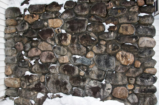 Snow covered stone chimney outdoors in rural new england