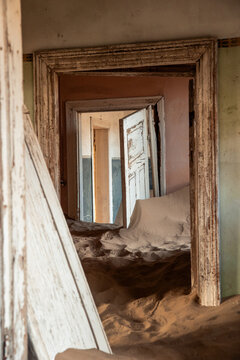 vertical Kolmanskop ghost town sand filling abandoned building interior